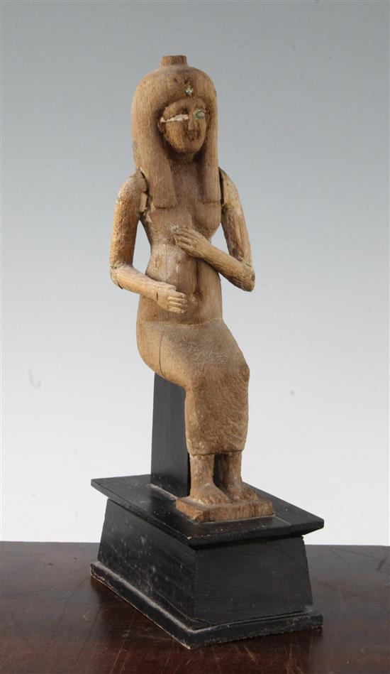 A carved wood figure of a seated ancient Egyptian woman, 12in.